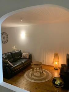a living room with a leather couch and a table at Appartement spacieux au calme in Vannes +20 photos