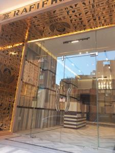 une façade de magasin avec une fenêtre reflétant un bâtiment dans l'établissement Golden View Pyramids Hotel, au Caire