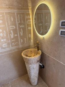 une salle de bain avec un lavabo et un miroir au mur dans l'établissement Golden View Pyramids Hotel, au Caire