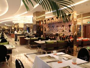 a restaurant with tables and chairs and a person in the background at Brigh Radiance Hotel Yantai in Yantai