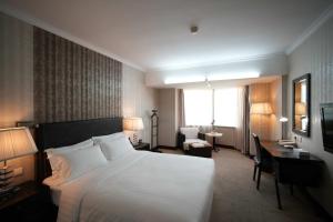 a hotel room with a large bed and a desk at Asia Hotel Beijing in Beijing +11 photos