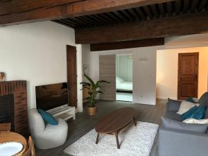 een woonkamer met een bank en een tafel bij Le Clos Saint-Jacques in Grenoble