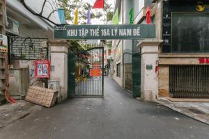 a gate with a sign that reads new hop tree real evil man die at Train Street Lux Homestay in Hanoi