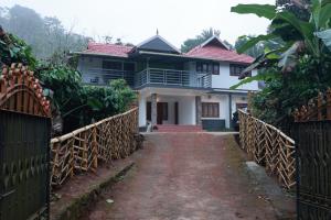 a house with a gate in front of it at Blizzard Pool Villa in Padinjarathara