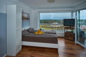 a bedroom with a bed and a large window at Haus Frische Brise Wohnung 11,05 mit Meerblick in Cuxhaven