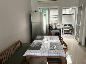 a kitchen with a table and a refrigerator at DJ Home in Ban Ko