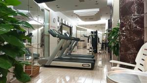 a gym with a treadmill in a room with plants at Asia Hotel Beijing in Beijing