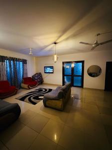 un grand salon avec un canapé et une table dans l'établissement Rosewood Cottage, à Karachi