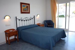 1 dormitorio con 1 cama azul y 1 silla azul en Hostal Brisamar, en San José