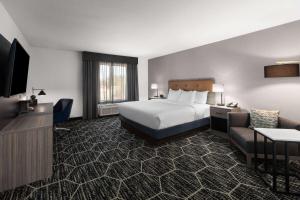 Una gran habitación de hotel con una cama y un sofá. en La Quinta Inn & Suites by Wyndham Meridian, en Meridian