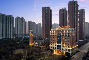 un perfil urbano con edificios altos y una torre de reloj en Ramada by Wyndham Zhumadian West Station, en Zhumadian