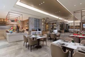 Un restaurante con mesas y sillas en una sala. en Ramada by Wyndham Zhumadian West Station, en Zhumadian