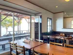 a restaurant with wooden tables and chairs and windows at Pension B,B, Dylan - Vacation STAY 22450v in Otsu