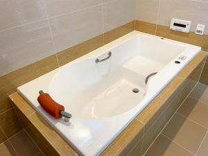 La salle de bains est pourvue d'une grande baignoire blanche. dans l'établissement Pension B,B, Dylan - Vacation STAY 22452v, à Ōtsu