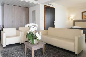 a living room with two couches and a table with flowers at Villa Azur in Villeneuve-Loubet