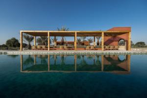 a swimming pool with a wooden pavilion next to the water at Mharo Khet Jodhpur in Mānaklāo