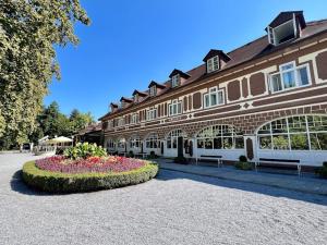 duży budynek z łóżkiem kwiatowym przed nim w obiekcie Hacienda in pure nature w mieście Ožegovci