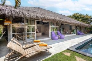 a resort with chairs and a swimming pool at Megalan Villa Balangan in Badung