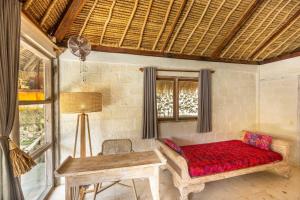 a living room with a red couch and a table at Megalan Villa Balangan in Badung
