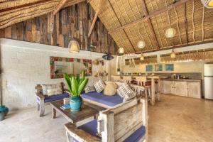 a living room with a table and chairs and a kitchen at Megalan Villa Balangan in Badung