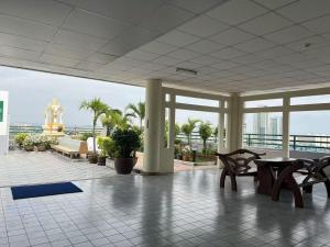 a lobby with tables and chairs in a building at 木子李 in Jomtien Beach