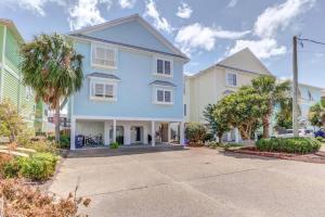 a blue house with palm trees in a street at One Block to the beach in Carolina Beach