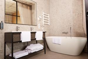 a bathroom with a tub and a sink and towels at Air Hotel in Karmėlava +26 photos