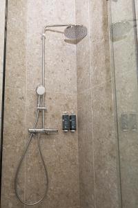 a shower with a glass door with a stool in it at Air Hotel in Karmėlava