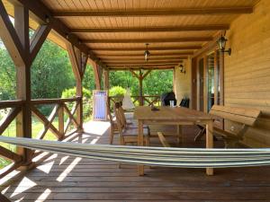 a wooden porch with a table and a bench on it at Siedlisko Topolany Agroturystyka in Topolany