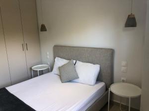 een slaapkamer met een bed met witte lakens en twee kussens bij Ammouses Apartment in Potamós