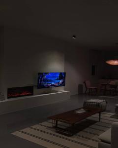 a living room with a couch and a tv on the wall at The Valley Villas in Sharīyah