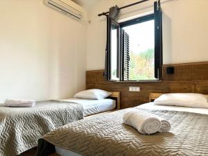 two beds in a room with a window at Guest house Kamelija in Budva