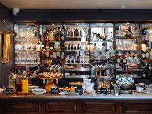 a bar with a counter with plates of food at Old Parsonage Hotel in Oxford