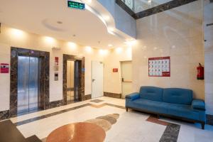 a lobby with a blue couch and a table at Saif Plus 3 Hotel by Orvana in Mecca