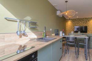 - une cuisine avec un comptoir, un évier et un comptoir dans l'établissement L 'Elegant - travelhome - 50m de la gare, à Villefranche-sur-Saône 15 autres photos