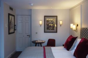 a hotel room with a bed and a table and a door at Old Parsonage Hotel in Oxford