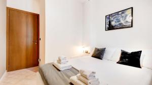 a bedroom with a white bed with towels on it at Casa di Monforte in Monforte dʼAlba