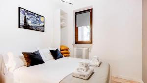 a white bedroom with a bed with towels on it at Casa di Monforte in Monforte dʼAlba