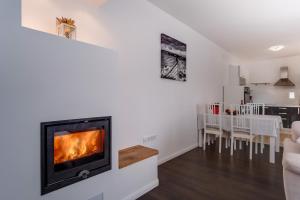 a living room with a fireplace and a dining room at Apartment Mirna in Nerezine