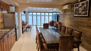 a dining room with a table and a view of the ocean at Lydias House kaputian in Kaputian