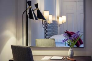 a room with a desk with a mirror and a bedroom at Old Parsonage Hotel in Oxford