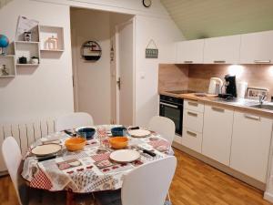 una cucina con tavolo, piatti e ciotole di Sea Bird parking draps fournis piscine partagée ad Arzon