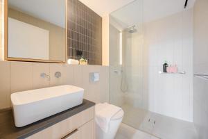 a bathroom with a sink and a toilet and a mirror at Luxury 2Br Apt Near Train Shopping Center in Sydney +24 photos