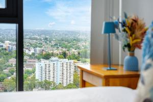a bedroom with a view of a city from a window at Luxury 2Br Apt Near Train Shopping Center in Sydney
