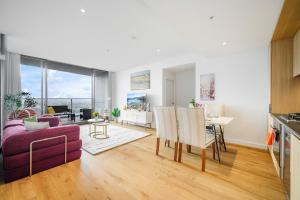 a living room with a purple couch and a table at Luxury 2Br Apt Near Train Shopping Center in Sydney