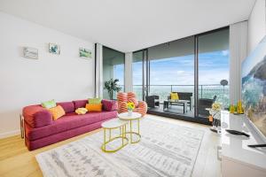 a living room with a purple couch and a table at Luxury 2Br Apt Near Train Shopping Center in Sydney