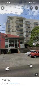 een groot gebouw met auto's geparkeerd op een parkeerplaats bij Stanford Suites 1 in Silang +1 foto