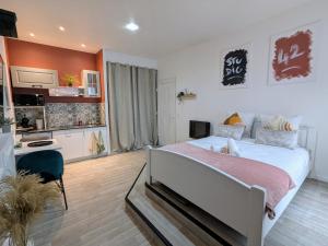 a bedroom with a large bed and a kitchen at Studio 42 with terrace in Roanne