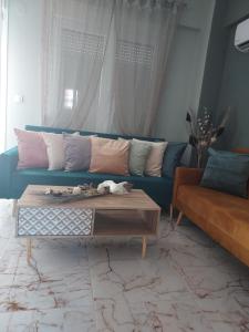 a living room with a blue couch and a coffee table at Duba Apartments 1 in Alexandroupoli