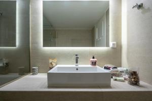 Un baño con un lavabo blanco y un espejo. en Piraiki Sea View Apt, 2bdrms, 4 pers by MPS, en Pireo